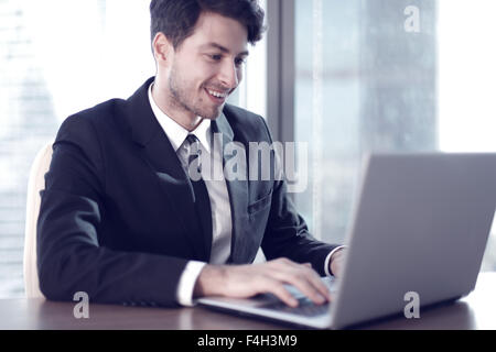 Busy businessman in office working on his laptop. Stock Photo