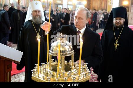 Russian President Vladimir Putin lights a candle during a visit to the ...