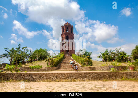 Tourists visit the Bell Tower, remains of an old red brick church built by Spanish at Bantay, Ilocos Sur, Luzon, Philippines. Stock Photo