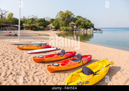 Landscape view of lakeside beach, Kaya Mawa, with colourful kayak canoes on the sandy shore, Likoma Island, Lake Malawi, Malawi, south-east Africa Stock Photo