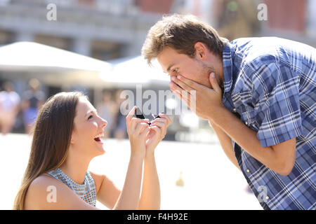 Proposal of a woman asking marry to a man in the middle of a street Stock Photo