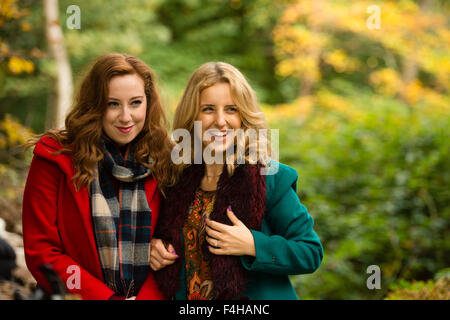 Aberystwyth Wales UK., Sunday 18 October 2015  Two happy smiling young women (Iulia Nicola and Rhian Daniell) enjoying a Sunday afternoon stroll in the autumnal woodlands at Penglais Park,  Aberystwyth, Wales   Photo Credit:  Keith Morris / Alamy Live News Stock Photo