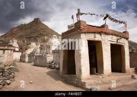 India, Jammu & Kashmir, Ladakh, Miru, old chortens and prayer wheel enclosure below hilltop temple Stock Photo