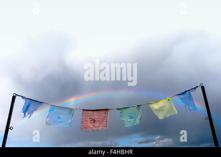 Rainbow over traditional Buddhist prayer flags; small mountain town of Salida; Colorado; USA Stock Photo