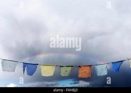 Rainbow over traditional Buddhist prayer flags; small mountain town of Salida; Colorado; USA Stock Photo