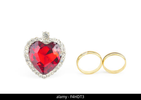 Red jewelry heart and two golden rings of man and woman isolated on white background Stock Photo