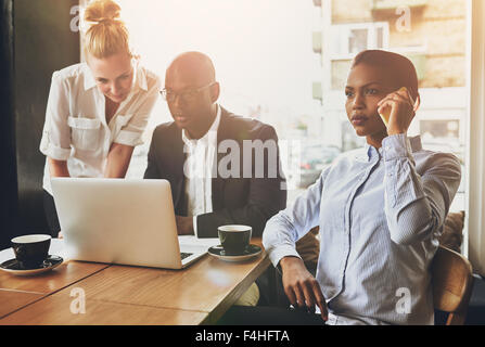 Business people working, using a laptop and cell phone. Meeting Stock Photo