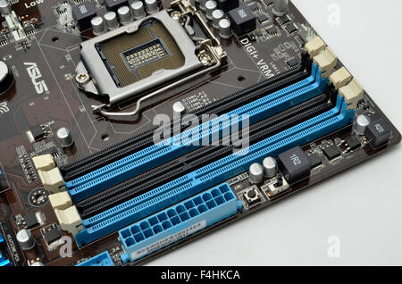 Dual channel DDR3 RAM memory sockets, power connector sockets, and Intel LGA1155 CPU processor socket on an ASUS motherboard. Stock Photo