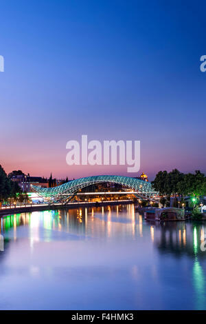 Dusk view of the Bridge of Peace, a pedestrian bridge spanning the Mtkvari River in Tbilisi, the capital of Georgia. Stock Photo