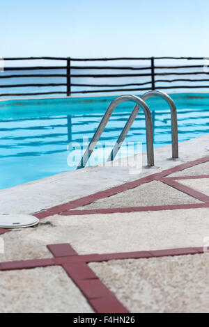 Grab bars ladder in swimming pool, outdoors at the day time Stock Photo