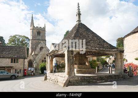 14th century market cross and St Andrew's Church, Castle Combe, Wiltshire, England, United Kingdom Stock Photo