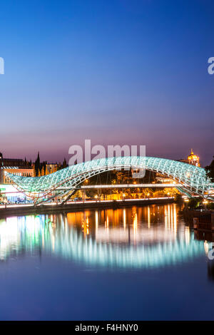 Dusk view of the Bridge of Peace, a pedestrian bridge spanning the Mtkvari River in Tbilisi, the capital of Georgia. Stock Photo