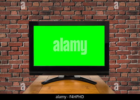 Modern television with chroma key green screen and red brick wall. Stock Photo