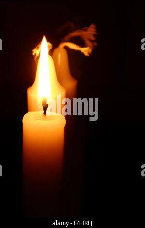 closeup of a burning candle against the black background Stock Photo