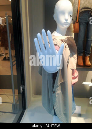 One dressed female mannequin in clothing store with stop hand symbol Stock Photo