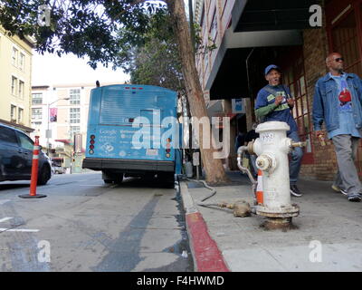 San Francisco, California, USA. 15th Oct, 2015. A shower bus that reads 'One Shower at a Time' has been connected to a fire hydrant on a street in San Francisco, California, USA, 15 October 2015. Two decommissioned city busses were refitted by the Lava Mae Project to include two spacious shower cabinets as well as toilets and sinks respectively. The busses operated by a bus driver and run by volunteers will stop in various districts of the city five days per week. Photo: Barbara Munker/dpa/Alamy Live News Stock Photo