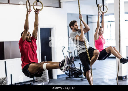 Athletes doing ring gymnastics and climbing rope Stock Photo