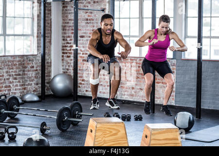 Fit couple doing jumping squats Stock Photo
