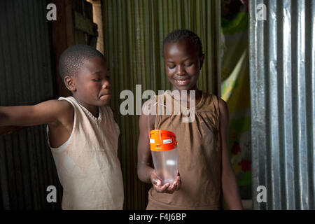 Young African boy and girl delighted to have been given a solar powered light Kamere Lake Naivasha Kenya Stock Photo