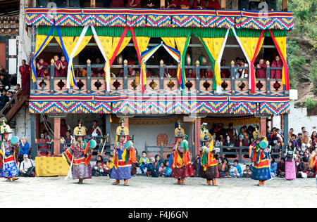 Monks watching dance performance at Paro Dzong (monastery) at the Paro Tsechu (annual monastery festival), Paro, Bhutan, Asia Stock Photo