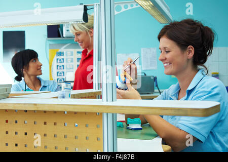 Three dental technicians working in a dental laboratory Stock Photo