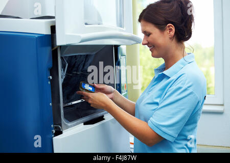 Dental technician with zircon material on a CAM Stock Photo