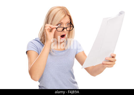 Studio shot of a shocked woman looking at the bills in disbelief isolated on white background Stock Photo