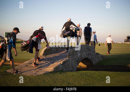 Golfers cross the world famous Swilcan (Burn) Bridge on the St. Andrews links golf Old Course, St. Andrews, Scotland, UK. Stock Photo