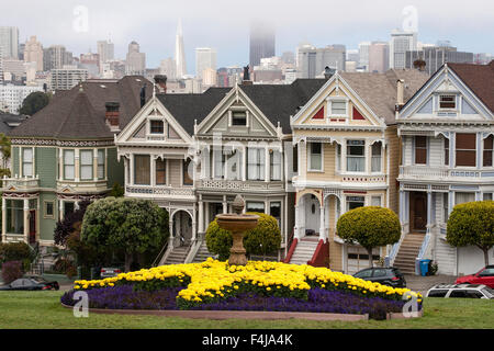 Wooden houses, Victorian houses, also Painted or Beautiful Ladies, Alamo Square, behind Downtown San Francisco skyscrapers Stock Photo