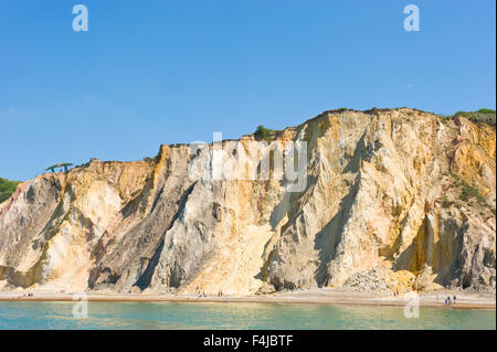A view of the multi-coloured sand cliffs at Alum Bay beach on the Isle Of Wight on a sunny day. Stock Photo