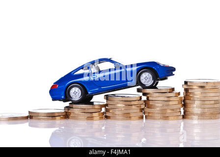 Model car on rising stacks of coins Stock Photo