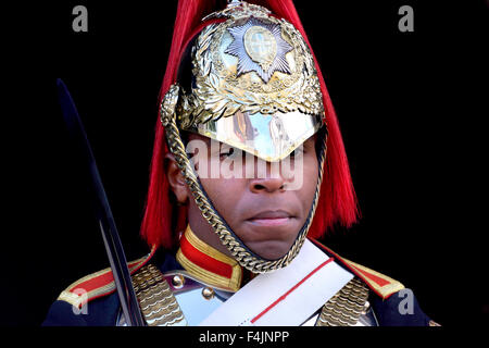 London, England, UK. Black member of the Horseguards on duty outside Horse  Guards Parade - Blues & Royals Stock Photo