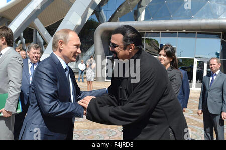 Russian President Vladimir Putin greets American actor Steven Seagal during a visit to the oceanarium on Russky Island September 4, 2015 in Vladivostok, Russia. Stock Photo