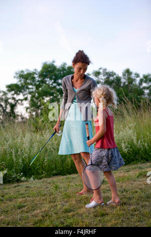 Mother and daughter playing badminton in garden Stock Photo