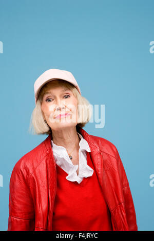 Senior woman smiling against blue background Stock Photo