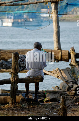 Old man sitting on wooden branch Stock Photo