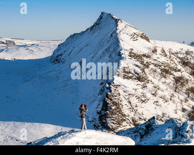 A female walker on the snowy ridge of Chrome Hill with Parkhouse Hill behind, Peak District National Park Stock Photo