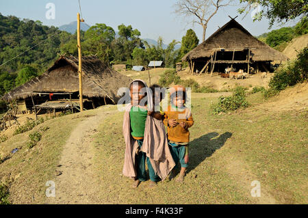 Three kids in front of typical stilted long houses of the Loi tribe in Wun Nyat, Shan State, Myanmar Stock Photo