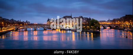 Ile de la Cite and Pont Neuf at dawn. The calm Seine River reflects the cloudy morning sky and street lamp lights. Paris, France Stock Photo