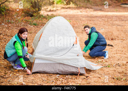 couple pitching tent in countryside Stock Photo