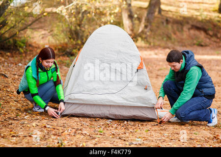 couple pitching tent in countryside Stock Photo