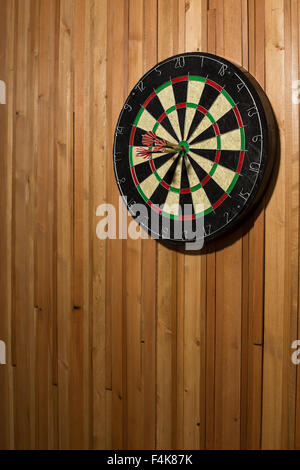 The darts isolated on wooden background Stock Photo