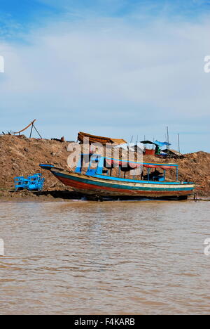 Small fishing boat out of the water at the Floating Villages on Tonle Sap River, Cambodia Stock Photo
