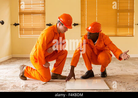 professional construction co-workers discussing floor tiles Stock Photo