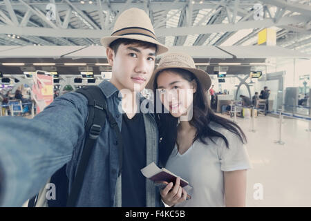 Asian couple tourist taking a selfie in airport before journey Stock Photo