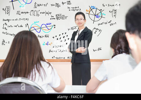 Asian teacher with a group of high school students in classroom Stock Photo