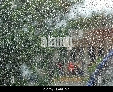 Raindrops form a dense pattern on a window pane Stock Photo