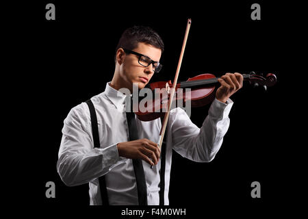 Young male violinist playing an acoustic violin on a black background Stock Photo