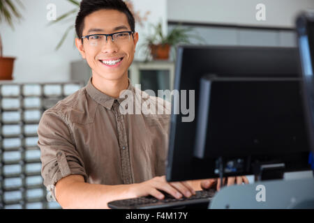 Portrait of a happy male student using personal computer in university Stock Photo