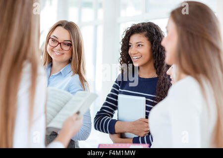 Portrait of a happy students speaking in the university hall Stock Photo